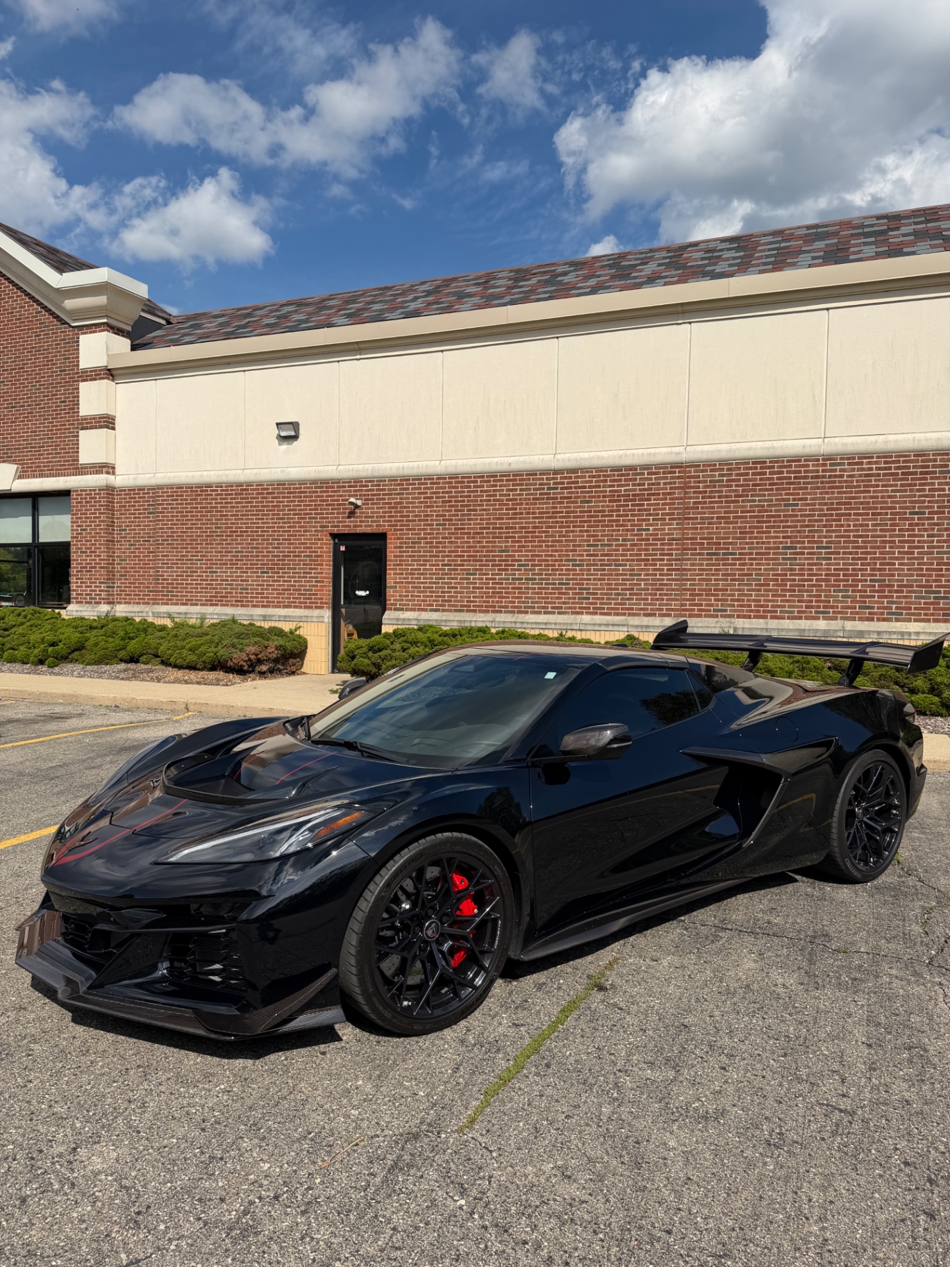 Black Chevrolet Corvette finished at DM Body Shop, parked outside the shop