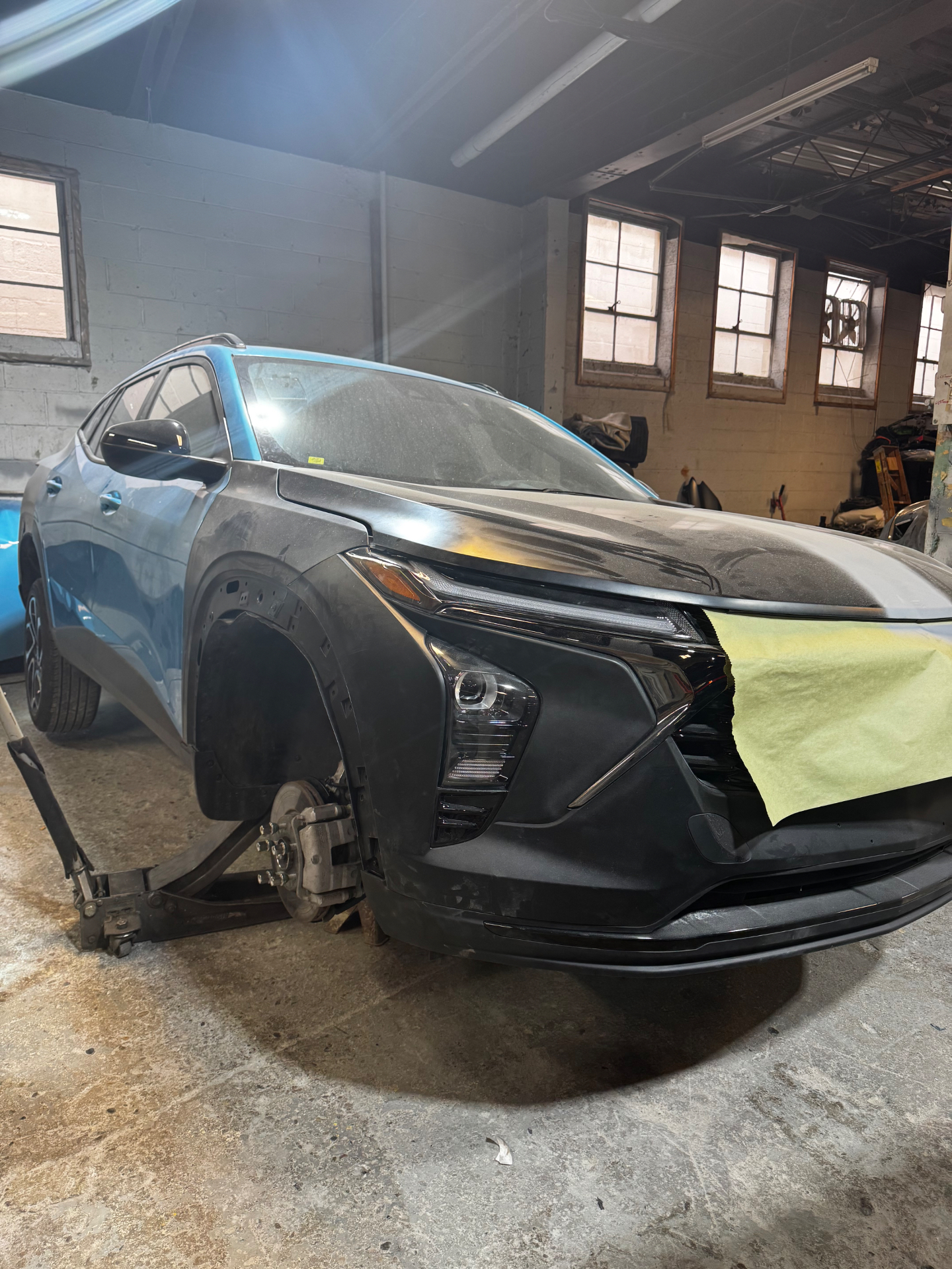 Blue Chevrolet Blazer with the front end apart during body repair